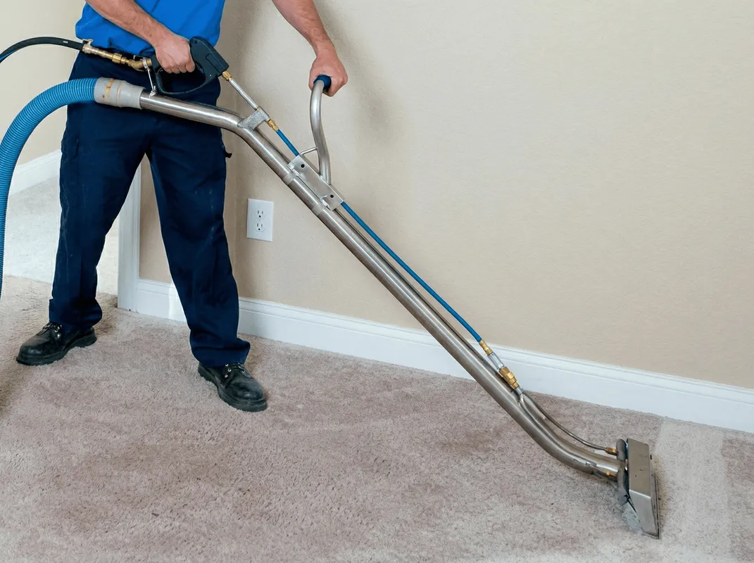 Professional operating a liquid removal machine on a carpeted floor in Newark, NJ